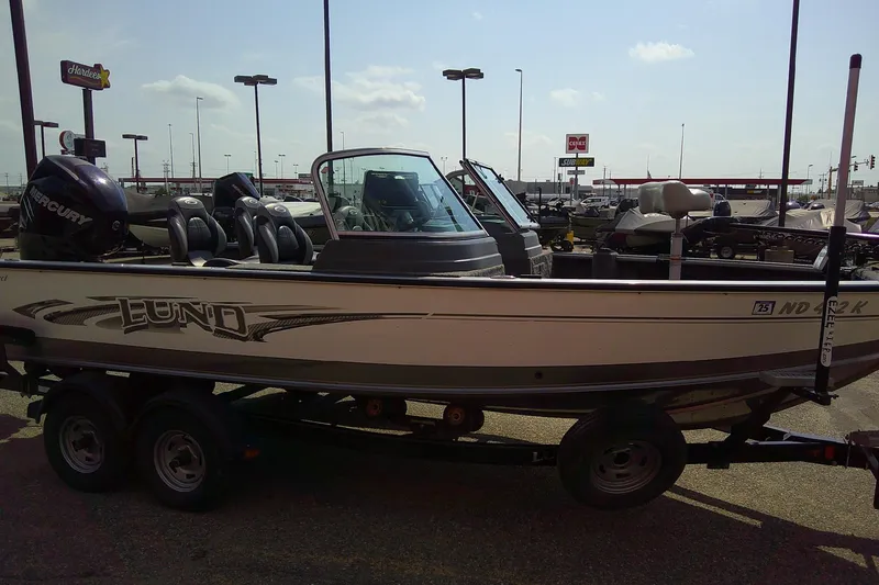 Slide: The Image of 2016 Lund 2025 Impact boat on trailer in parking lot, featuring Mercury engine. - 5