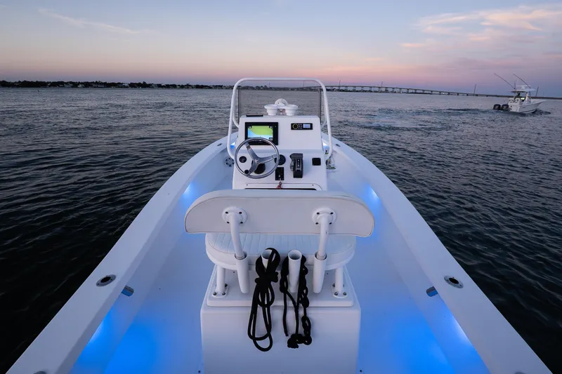 Slide: The Image of 2016 Intruder 198 Tunnel Drive boat on water at sunset, featuring illuminated deck. - 15