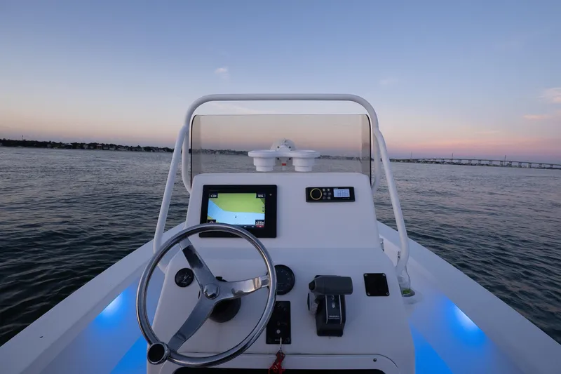 Slide: The Image of Cockpit view of 2016 Intruder 198 Tunnel Drive boat at sunset on open water. - 17