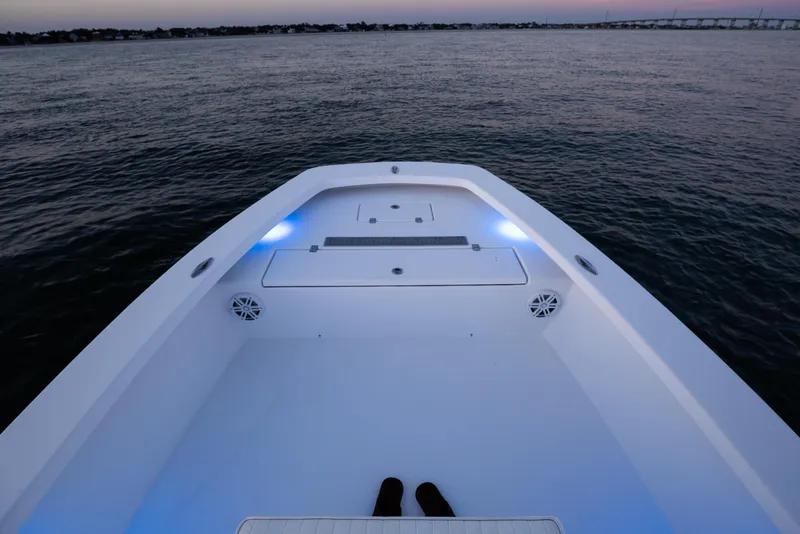 Slide: The Image of Bow view of 2016 Intruder 198 Tunnel Drive boat at dusk on calm water. - 21