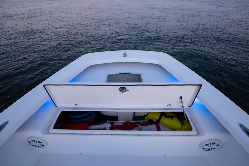 Slide: The Image of Open storage compartment on 2016 Intruder 198 Tunnel Drive boat, with ocean backdrop. - 22