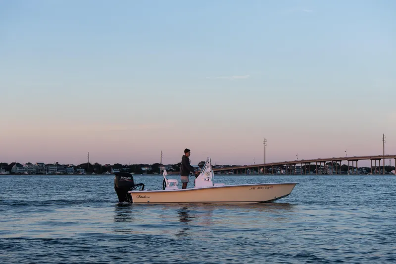 Slide: The Image of Man on 2016 Intruder 198 TUNNEL DRIVE boat at sunset near bridge. - 6