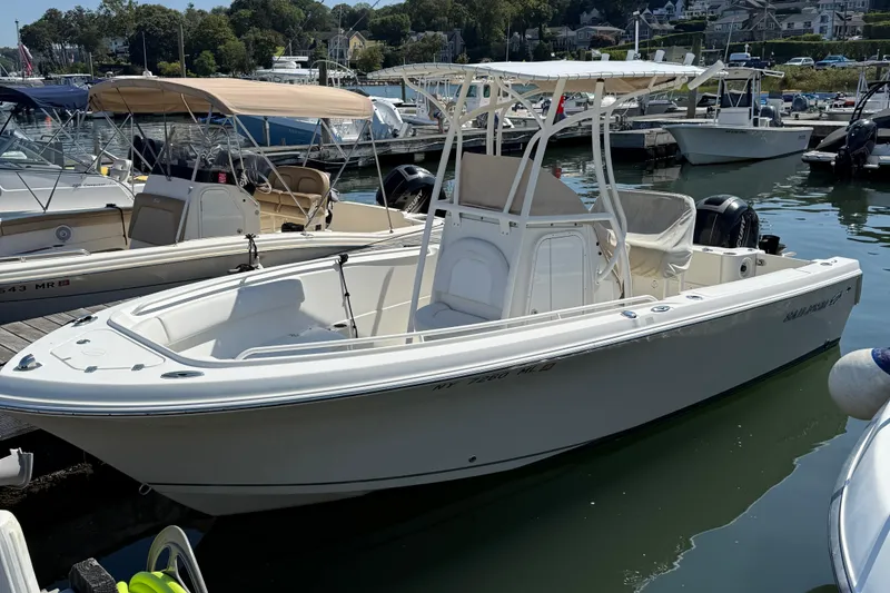 The Image of 2015 Sailfish 220 CC boat docked in a marina, surrounded by other vessels. - 0