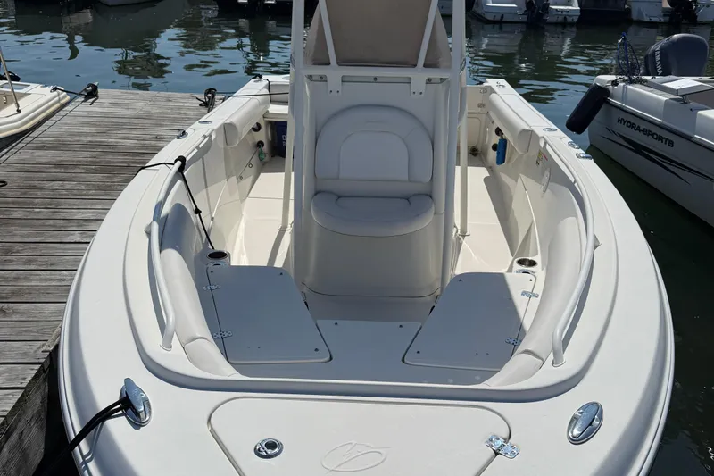 Slide: The Image of 2015 Sailfish 220 CC boat docked, featuring spacious seating and sleek design. - 2