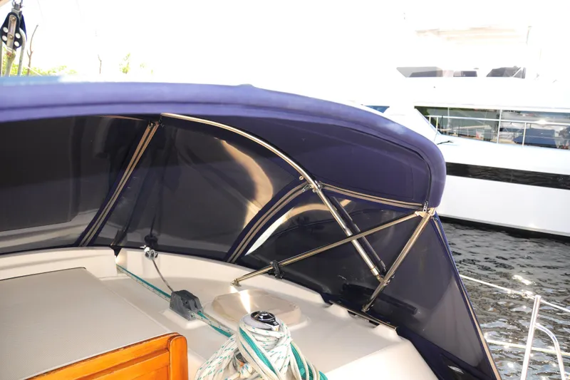 Slide: The Image of 2002 Island Packet 420 sailboat cockpit with blue canopy and ropes. - 11