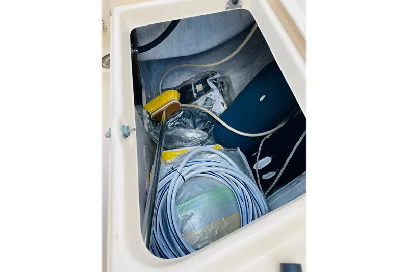 Slide: The Image of Storage compartment of 2002 Island Packet 420 sailboat with cleaning supplies and ropes. - 34