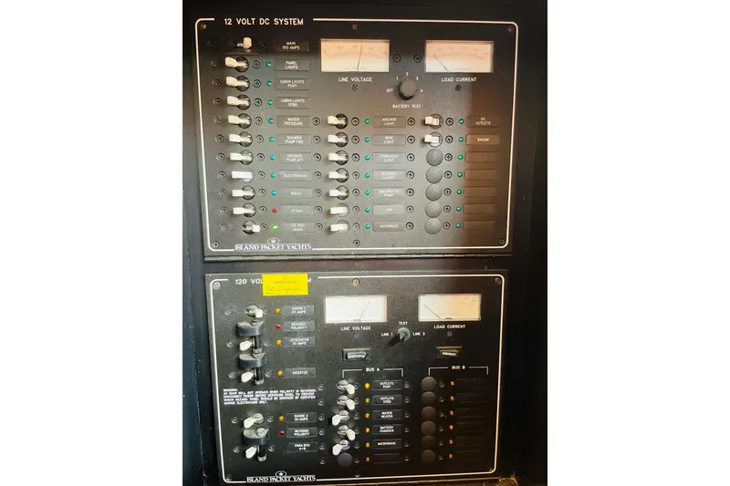 Slide: The Image of Electrical control panel of a 2002 Island Packet 420 yacht, featuring 12V and 120V systems. - 49