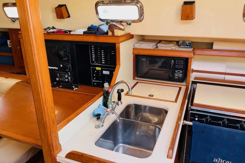 Slide: The Image of 2002 Island Packet 420 yacht interior with kitchen sink, microwave, and control panel. - 52