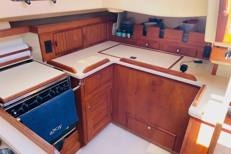 Slide: The Image of 2002 Island Packet 420 yacht kitchen with wooden cabinetry and modern appliances. - 54