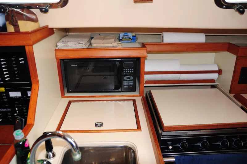Slide: The Image of 2002 Island Packet 420 yacht kitchen with microwave, stove, and sink. - 55