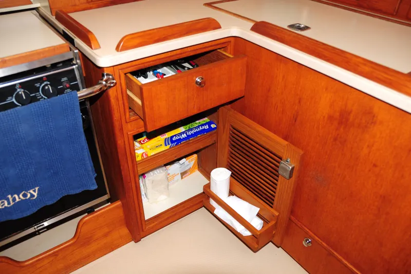 Slide: The Image of 2002 Island Packet 420 yacht kitchen with wooden cabinetry and storage compartments. - 56