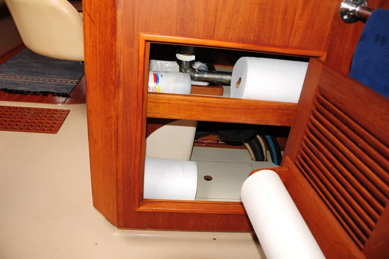 Slide: The Image of Interior storage compartment on 2002 Island Packet 420 yacht with paper towels and supplies. - 58