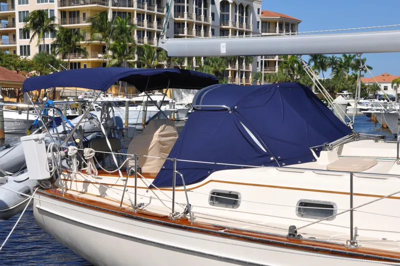 Slide: The Image of 2002 Island Packet 420 sailboat docked at marina with blue canvas covers. - 6