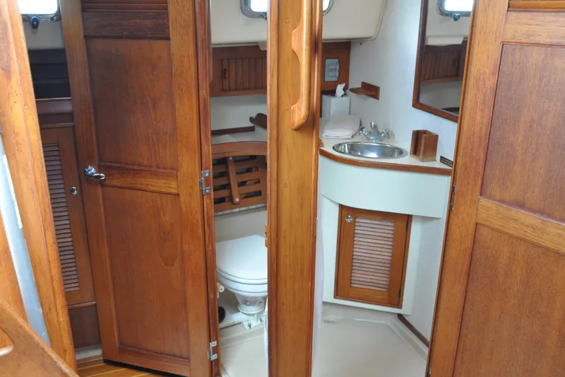 Slide: The Image of 2002 Island Packet 420 yacht bathroom with wooden cabinetry and compact sink. - 64