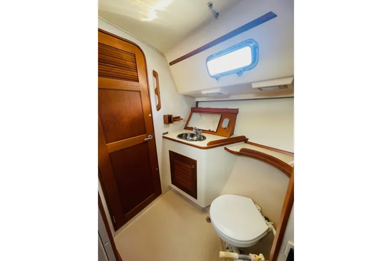 Slide: The Image of 2002 Island Packet 420 yacht bathroom with wooden accents and compact design. - 65