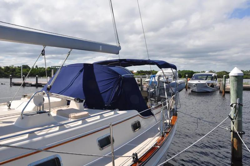 Slide: The Image of 2002 Island Packet 420 sailboat docked at marina under cloudy sky. - 7
