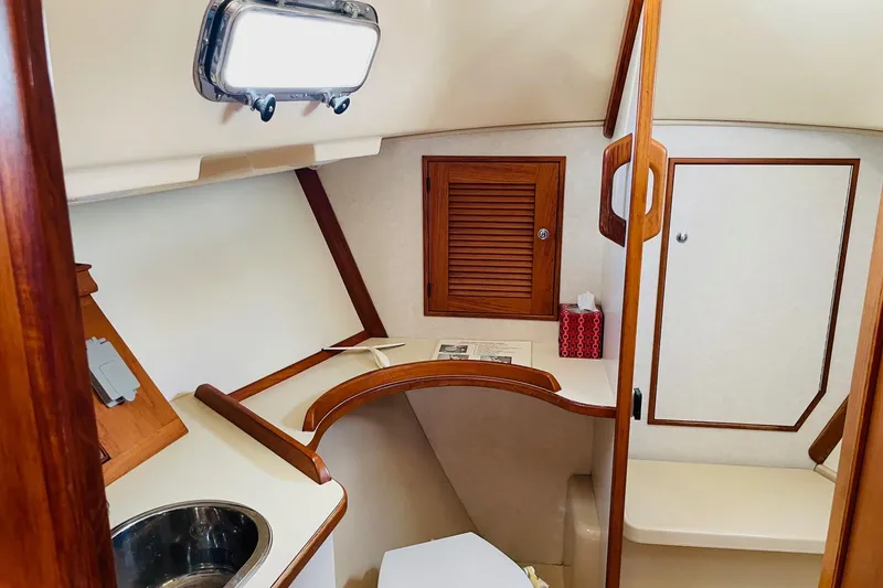 Slide: The Image of 2002 Island Packet 420 yacht interior with wooden cabinetry and compact bathroom. - 75