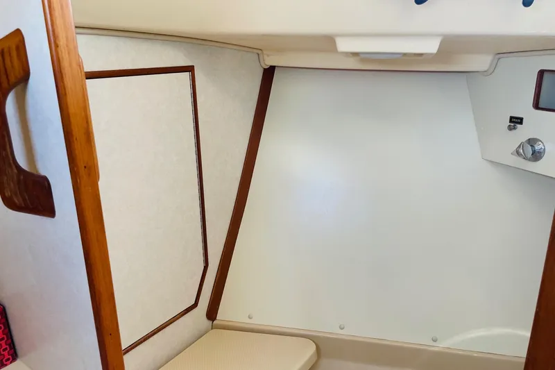 Slide: The Image of Interior cabin of 2002 Island Packet 420 sailboat, featuring wood accents and control panel. - 77