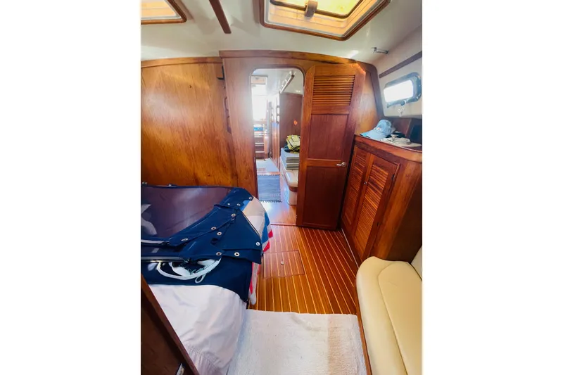 Slide: The Image of Interior of 2002 Island Packet 420 sailboat with wooden cabinetry and cozy furnishings. - 82