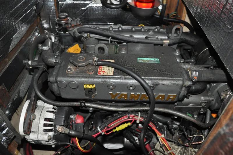 Slide: The Image of Engine compartment of a 2002 Island Packet 420 sailboat, featuring a Yanmar engine. - 84