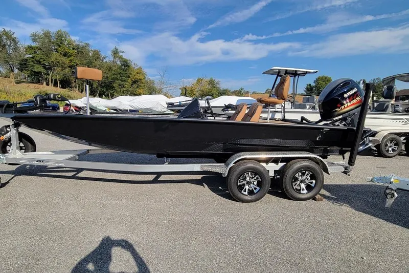 The Image of 2026 Xpress H20 Bass boat on trailer, parked outdoors under clear sky. - 1