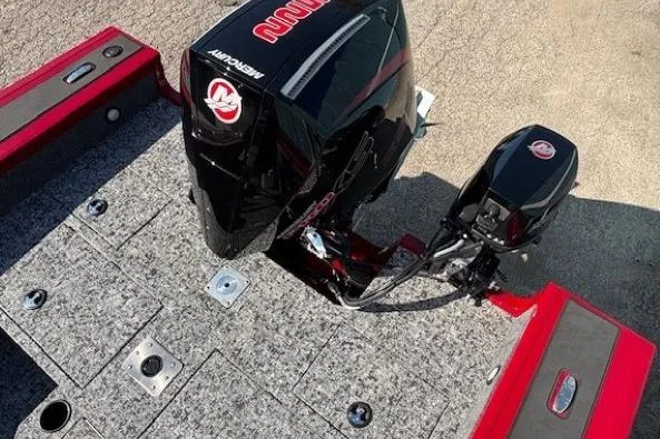 Slide: The Image of 2025 Tracker Targa V-19 WT Tournament Edition boat with Mercury outboard motor, red and gray deck. - 25