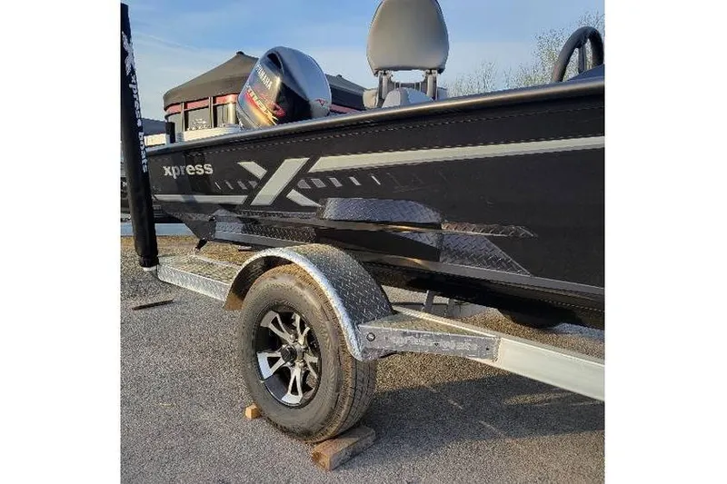 The Image of 2026 Xpress H20 Bass boat on trailer, featuring sleek black design and modern graphics. - 1