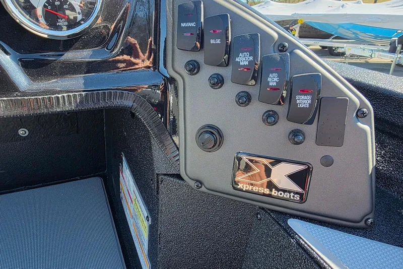 Slide: The Image of Control panel of 2026 Xpress H20 Bass boat with switches and gauge. - 18