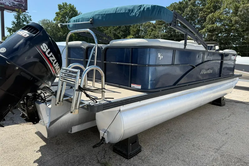Slide: The Image of 2020 Manitou 21 Aurora LE pontoon boat with Suzuki outboard motor, parked outdoors. - 1