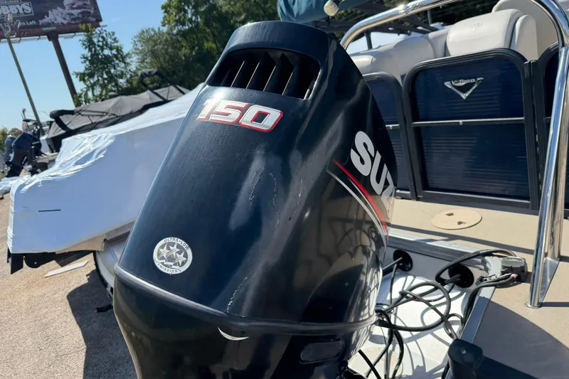 Slide: The Image of 2020 Manitou 21 Aurora LE with Suzuki 150 outboard motor, parked outdoors. - 2