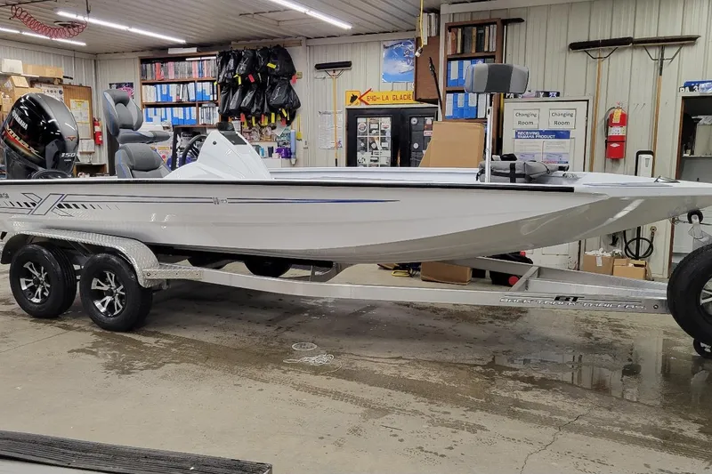 The Image of 2026 Xpress H20 Bass boat in a garage, on a trailer, with Yamaha engine. - 1