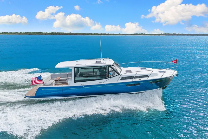 Slide: The Image of 2024 MJM 42 yacht cruising on open blue sea under clear sky. - 1