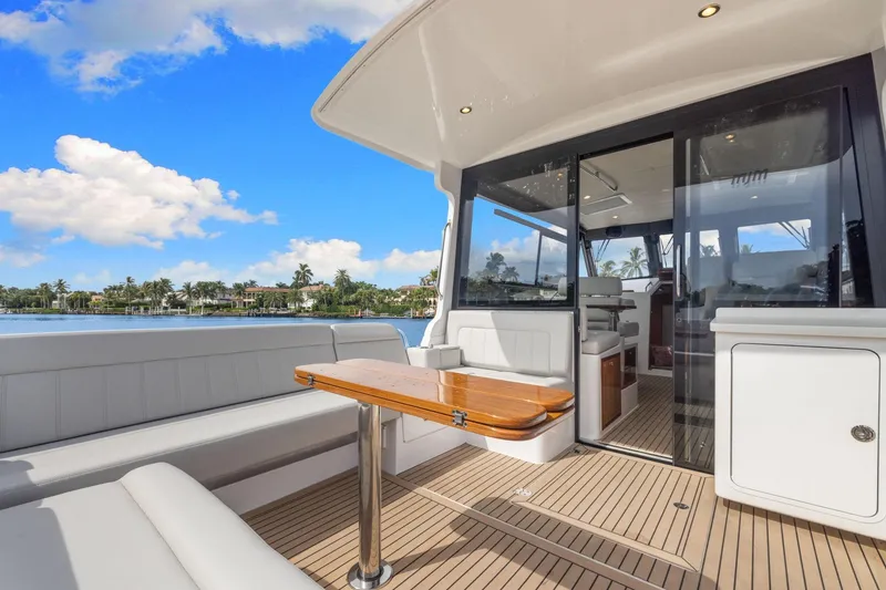 Slide: The Image of 2024 MJM 42 yacht with elegant seating and scenic waterfront view. - 12