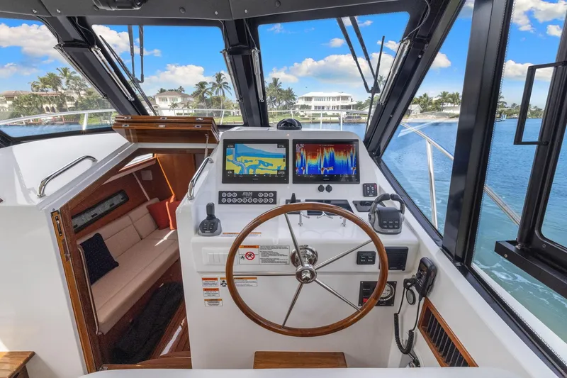 Slide: The Image of 2024 MJM 42 yacht helm with navigation screens, steering wheel, and luxurious interior view. - 29