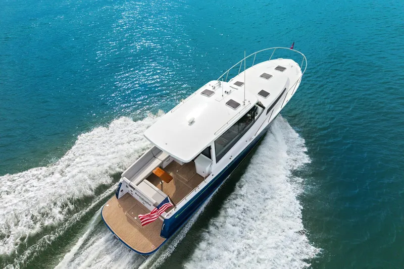 Slide: The Image of 2024 MJM 42 yacht cruising on clear blue water, showcasing sleek design and performance. - 3