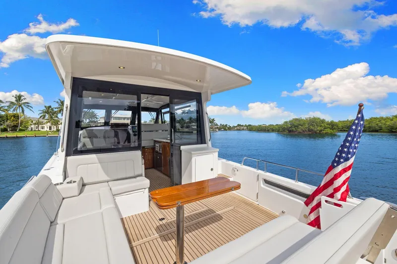 Slide: The Image of 2024 MJM 42 yacht interior with American flag, docked on a sunny day. - 4