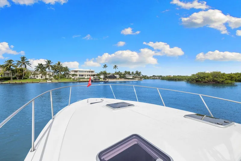 Slide: The Image of 2024 MJM 42 yacht cruising on a sunny day with palm trees and blue sky. - 60