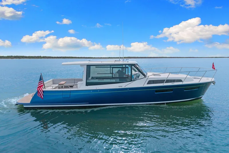 Slide: The Image of 2024 MJM 42 yacht cruising on calm waters under a clear blue sky. - 61