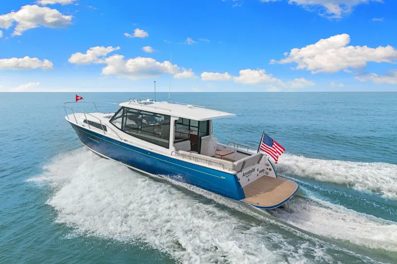 Slide: The Image of 2024 MJM 42 yacht cruising on open water under a clear blue sky. - 64