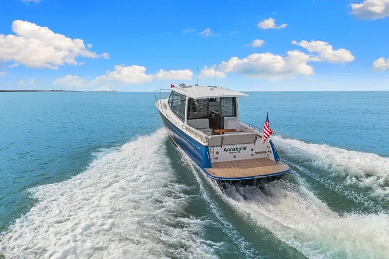 Slide: The Image of 2024 MJM 42 yacht cruising on open water under a clear blue sky. - 65