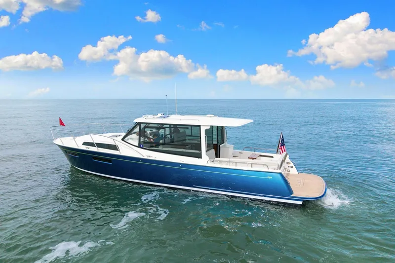 Slide: The Image of 2024 MJM 42 yacht cruising on open water under a clear blue sky. - 66