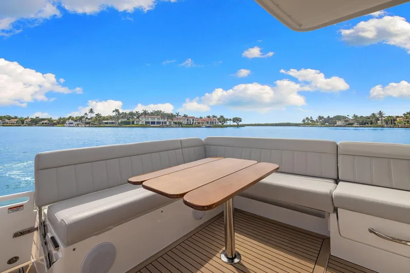 Slide: The Image of 2024 MJM 42 yacht deck with seating and table, overlooking serene waterfront view. - 7
