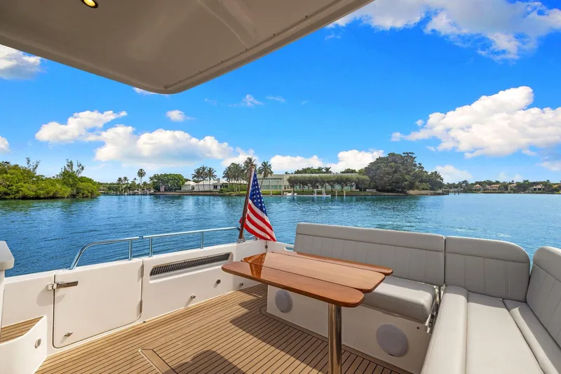 Slide: The Image of 2024 MJM 42 yacht deck with seating, table, and American flag on a sunny day. - 9