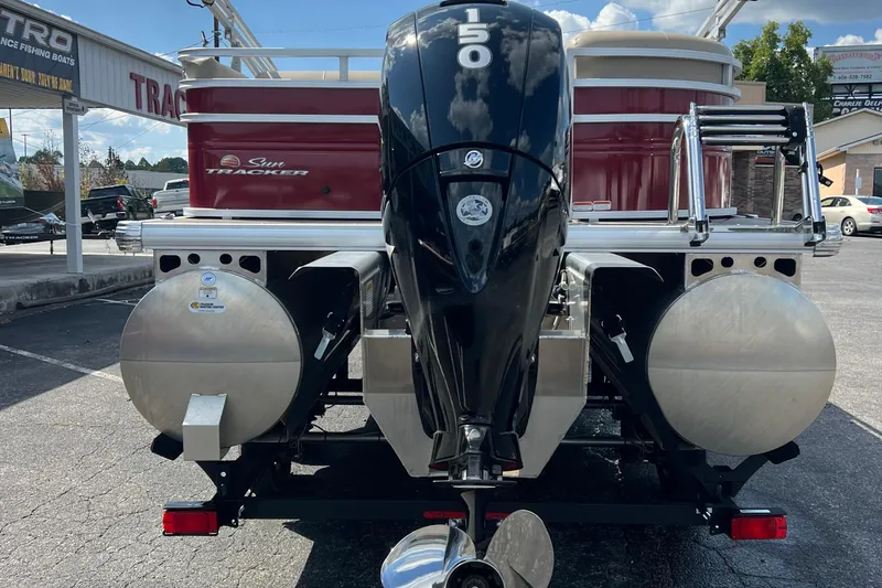 Slide: The Image of 2024 Sun Tracker Party Barge 22 RF XP3 with powerful outboard motor, parked outdoors. - 7