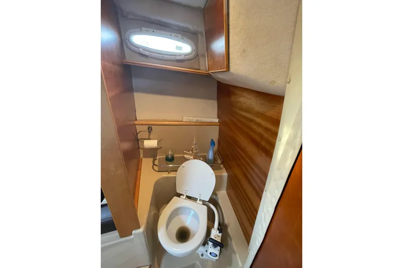 Slide: The Image of 2016 Cutwater C-24 Coupe boat bathroom with toilet and wooden interior. - 13