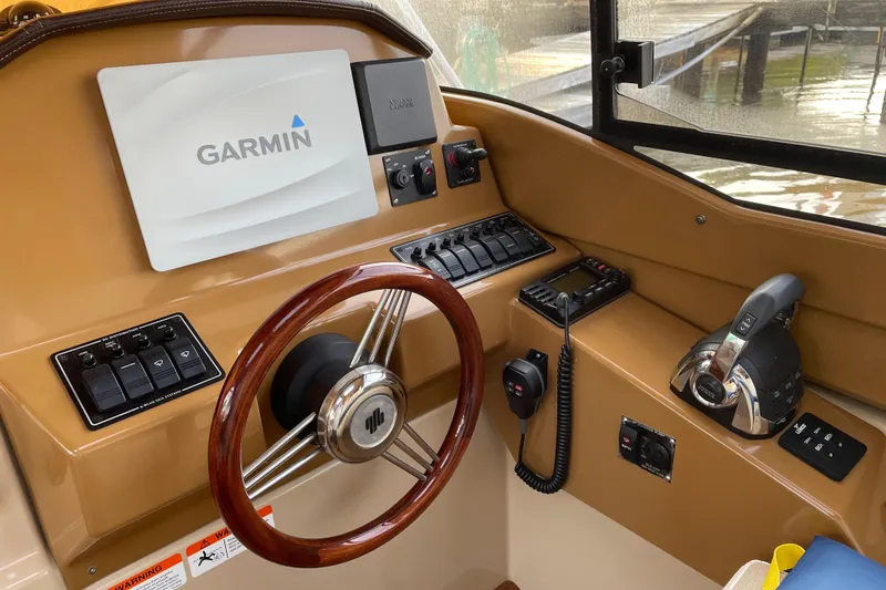 Slide: The Image of 2016 Cutwater C-24 Coupe helm with Garmin navigation, wood steering wheel, and control panel. - 15