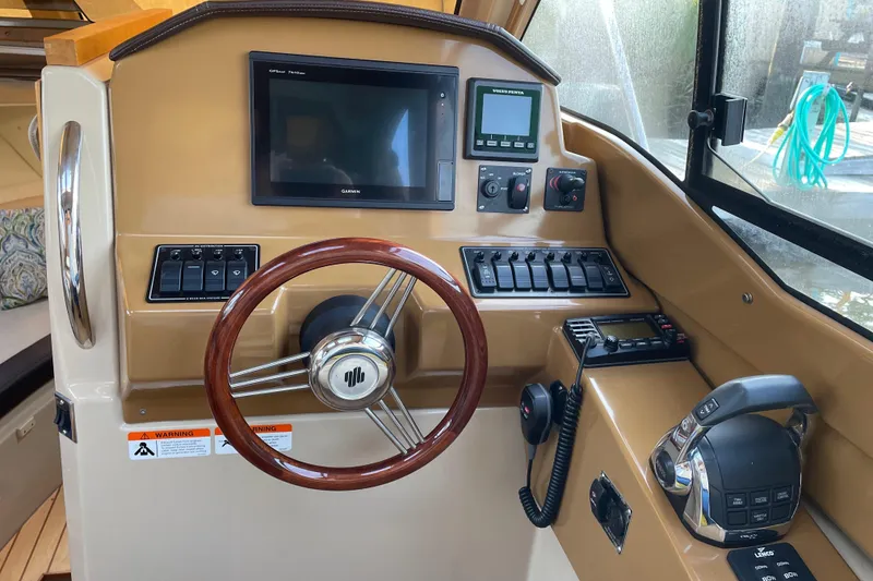 Slide: The Image of 2016 Cutwater C-24 Coupe helm with steering wheel, controls, and navigation display. - 16