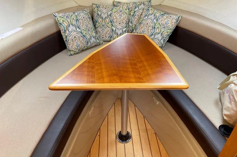 Slide: The Image of 2016 Cutwater C-24 Coupe interior with wooden table and patterned cushions. - 24