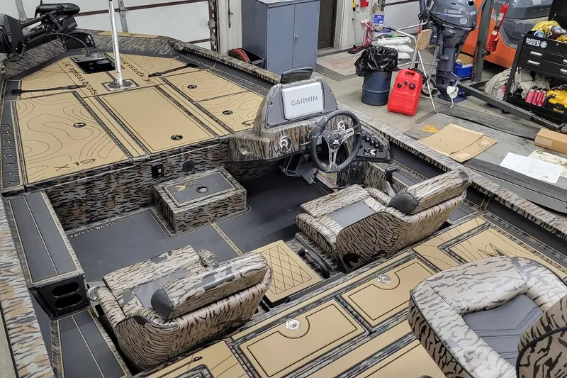 Slide: The Image of 2026 Xpress X19 Pro boat interior with camouflage seats and Garmin navigation system. - 5