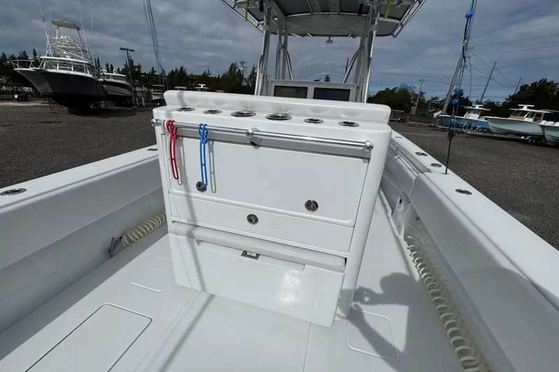 Slide: The Image of 2022 Contender 32 ST boat interior with storage and rod holders, docked outdoors. - 16